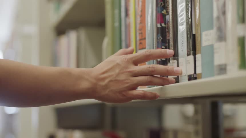 Fingers running down book shelf