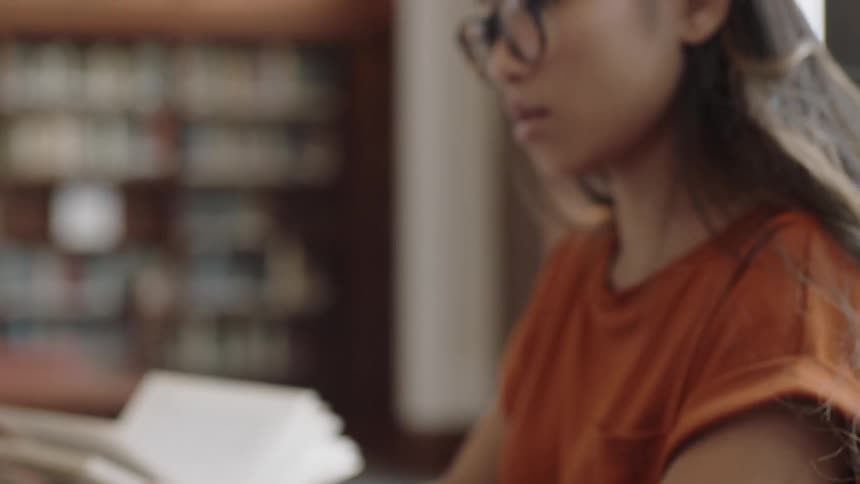 Woman working on laptop and smart phone on books