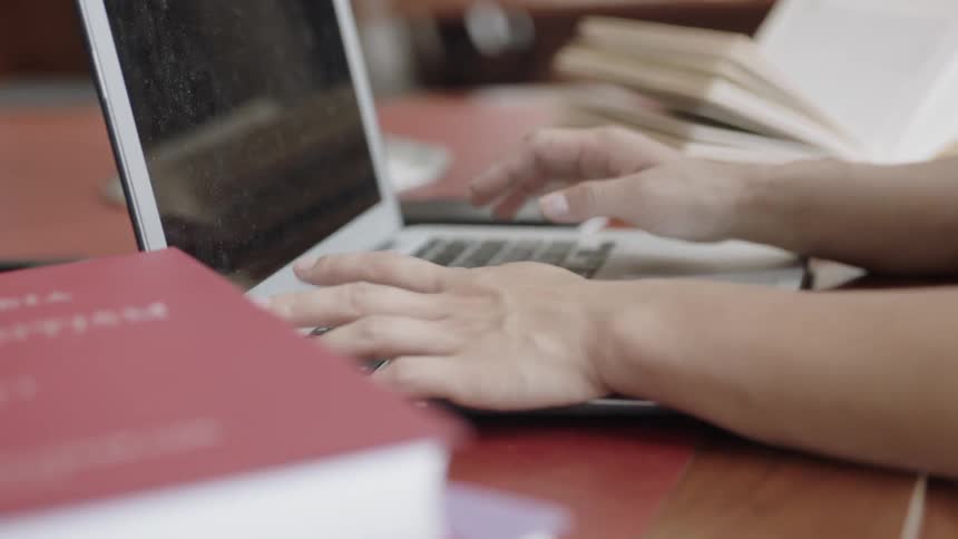 Hands working on homework at the library