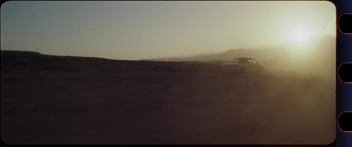 Yellow car racing through dusty desert scenery