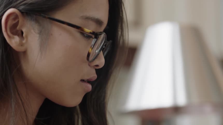Asian woman smirking as she looks down