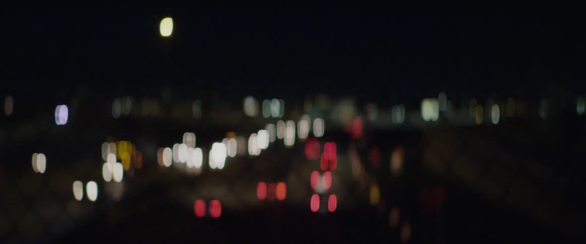 Car lights shine as traffic moves on a highway at night