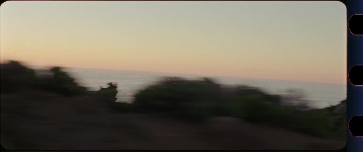 Sea of clouds with mountain region in the foreground shot out of a driving car at sunset