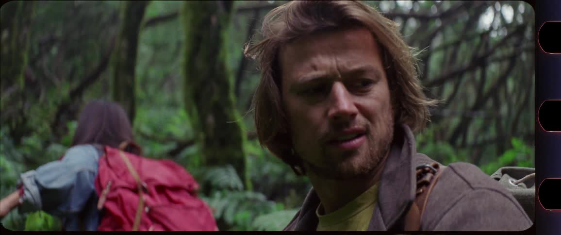 Woman turning around to motivate a man while hiking through the forest