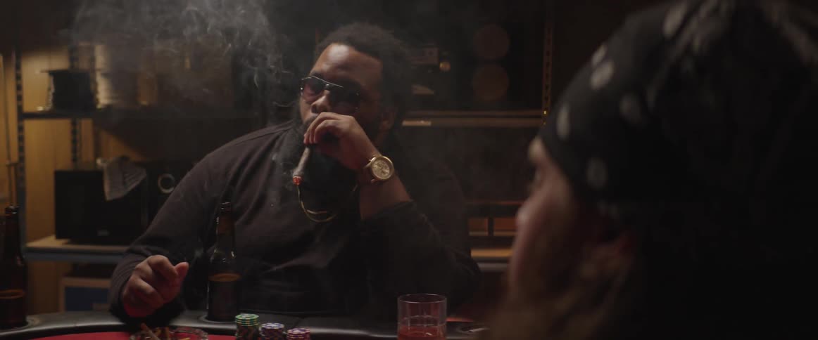 A group of people playing poker and smoking