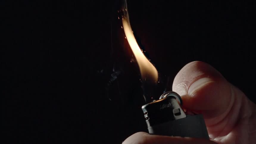 A person lighting a disposable lighter