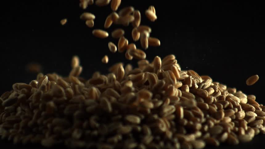 Beans falling on a large pile in a dark area