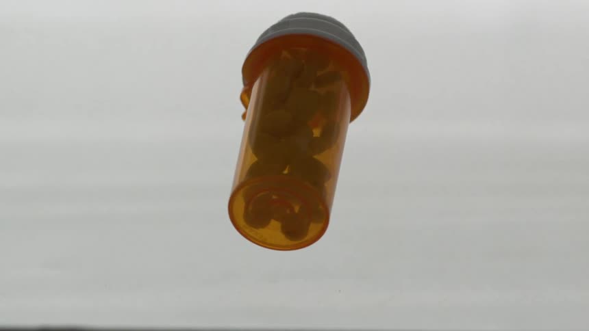 A bottle of pills is dropped and bounces
