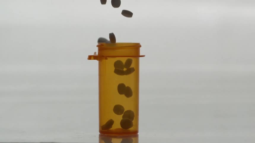 Pills falling into a pill bottle