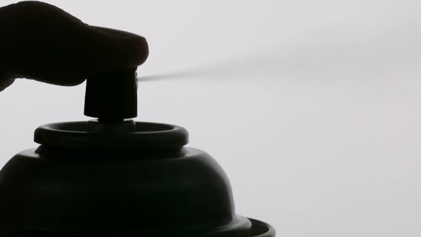 A finger pressing on an aerosol can