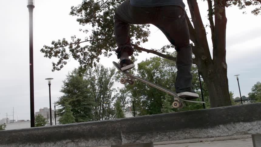 Man skateboarding and jumping on a city sidewalk