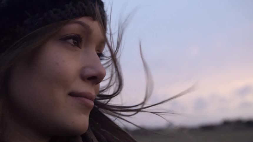 A woman standing outside in the wind smiling