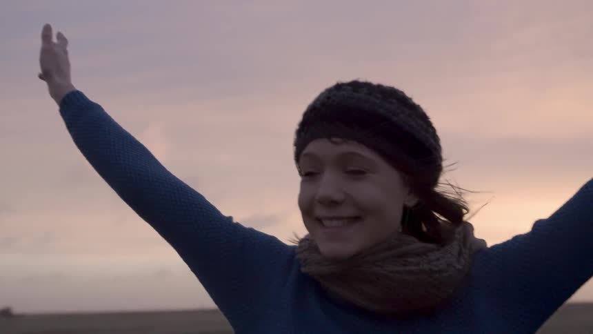 Woman holding up her hands with water in the background