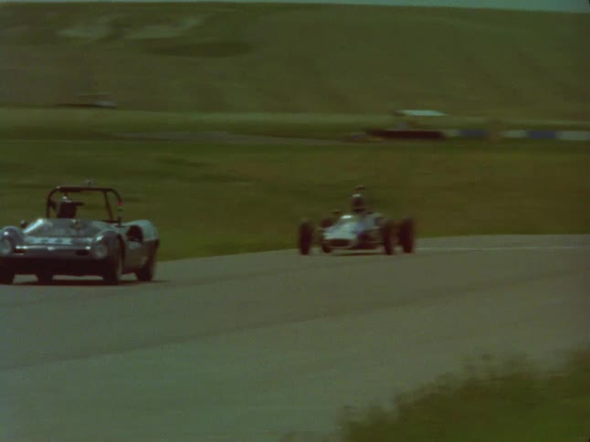 Race cars speed down a track
