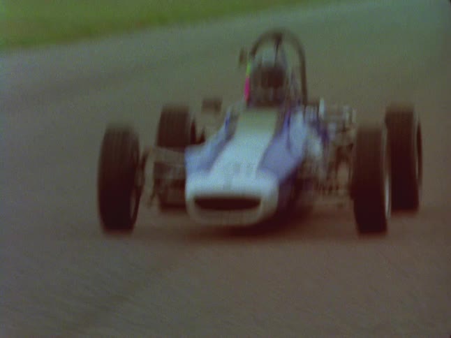 A race car driver speeds down a track
