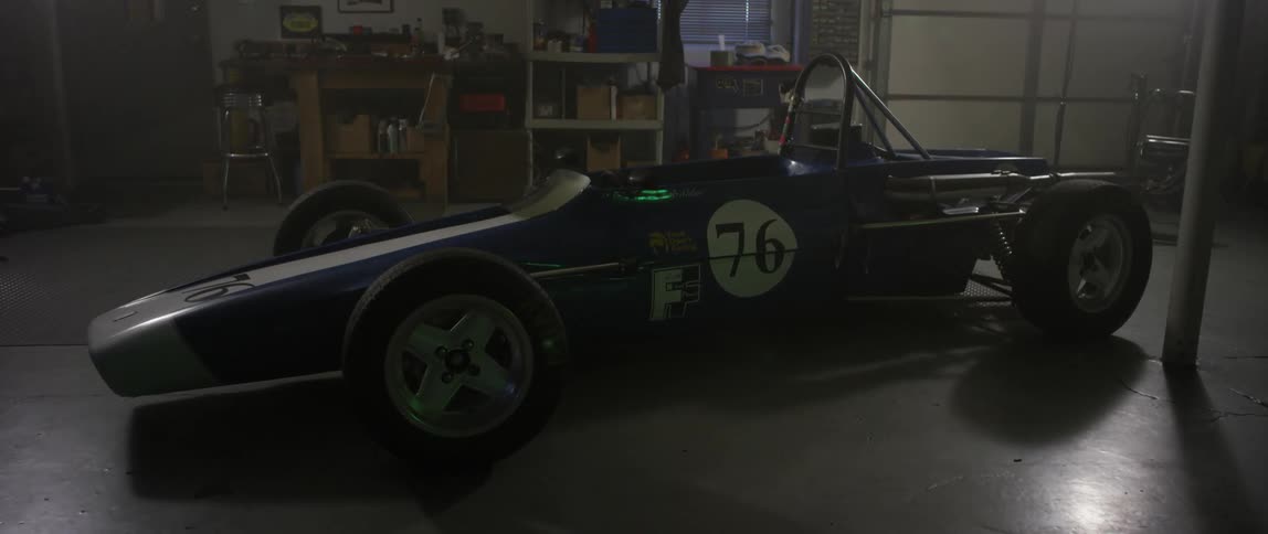An old race car parked in a garage