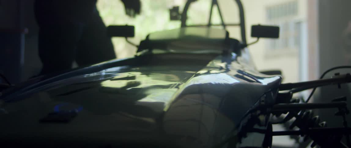 Light pouring into a garage revealing a race car