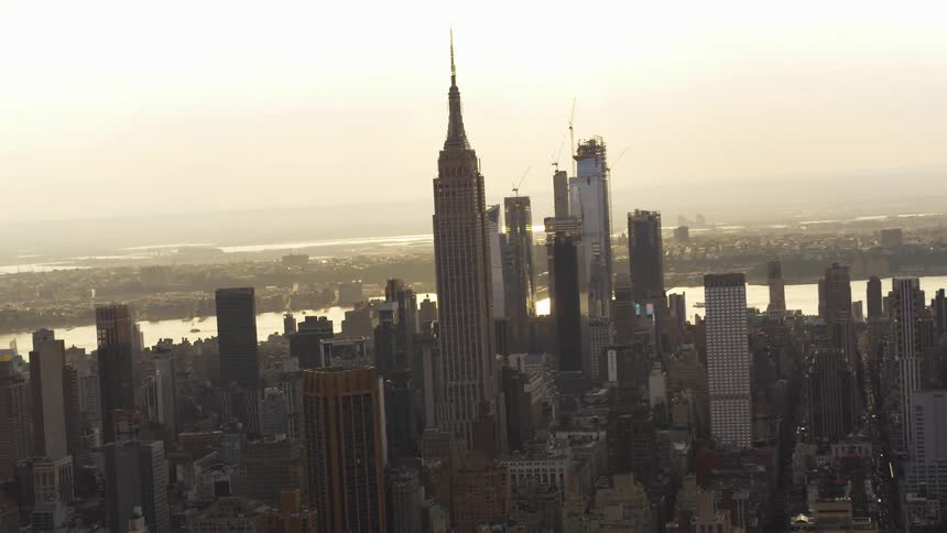 The empire state building standing tall in the new york city skyline at sunrise