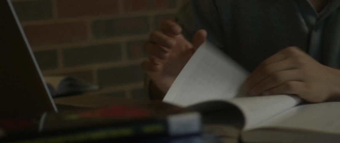 A person flips through a book on a desk
