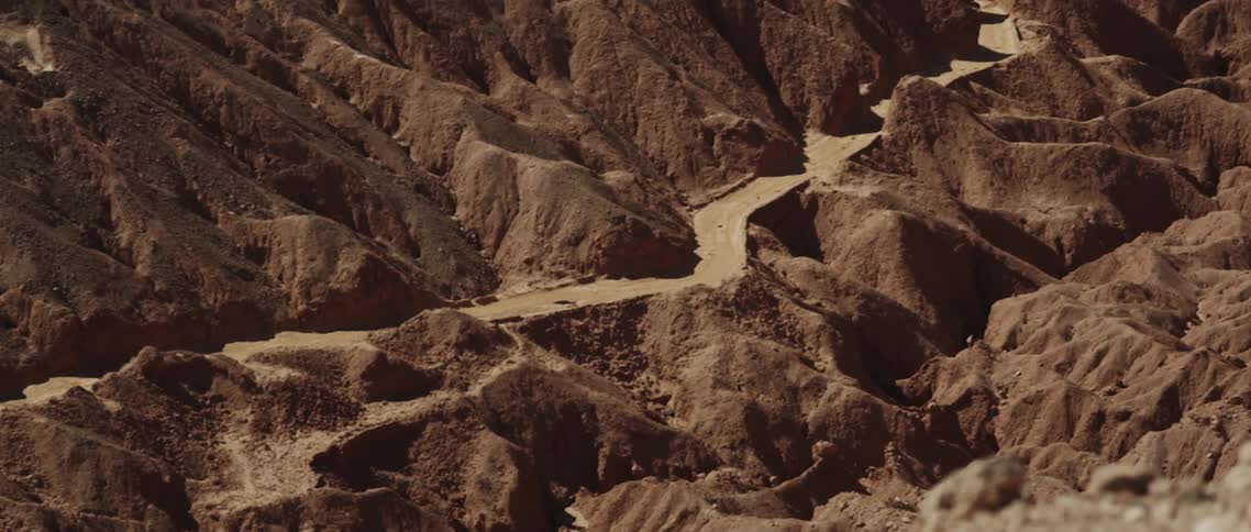 A small road lines a large canyon on a sunny day