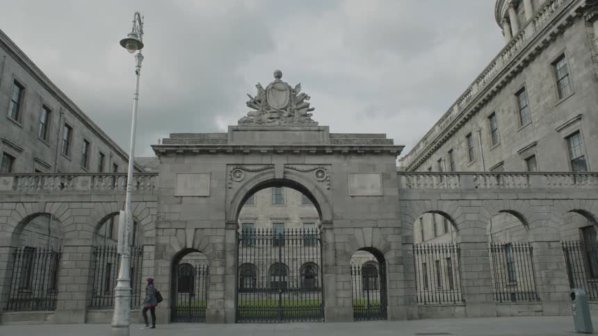 A woman walks in front of a large city building