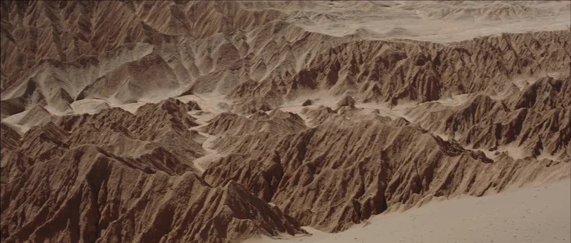 A large canyon is covered in sand on a sunny day