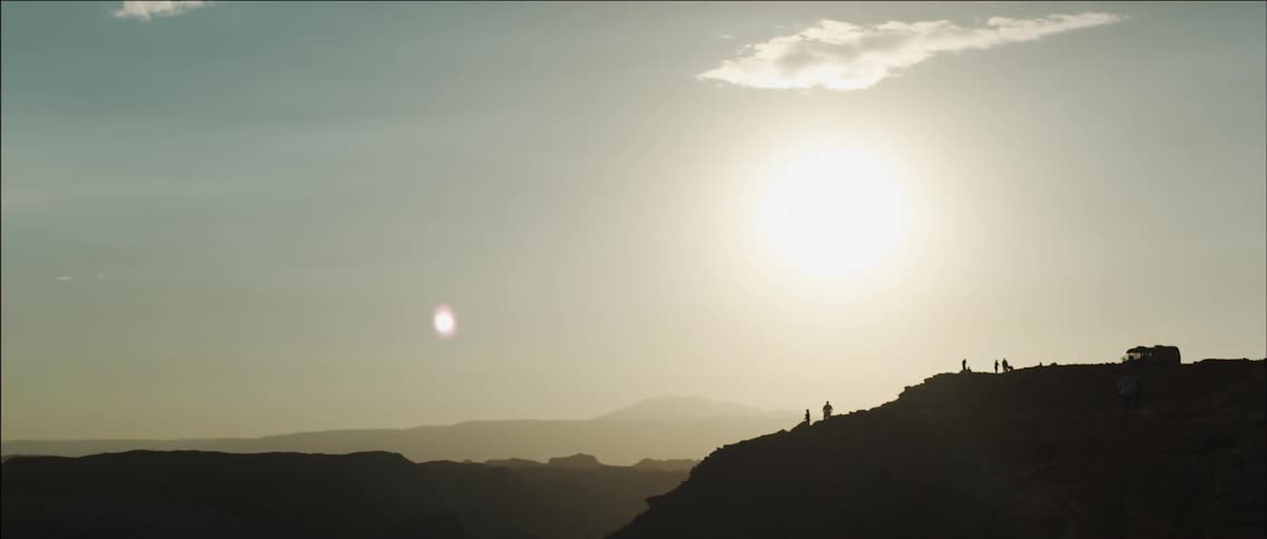 People are standing on a cliff on a foggy day