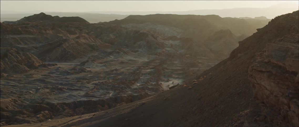 A large mountain range is empty at sunset on a cloudy day