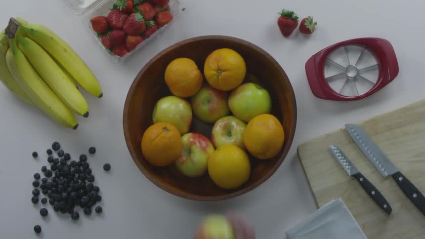Person grabs apple from fruit bowl
