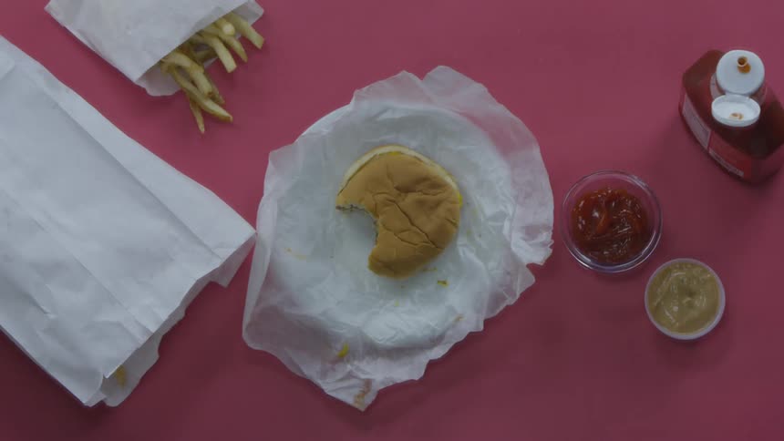A person picking up their drink from the table