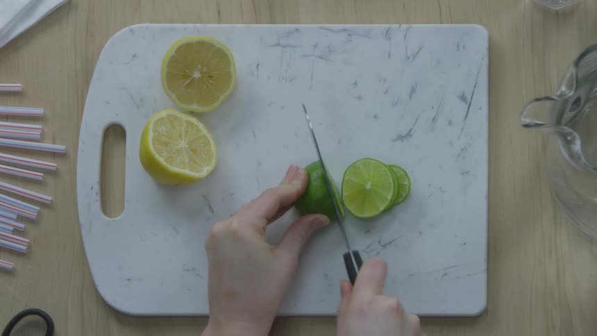 Woman slicing a lime on a cutting board for drinks