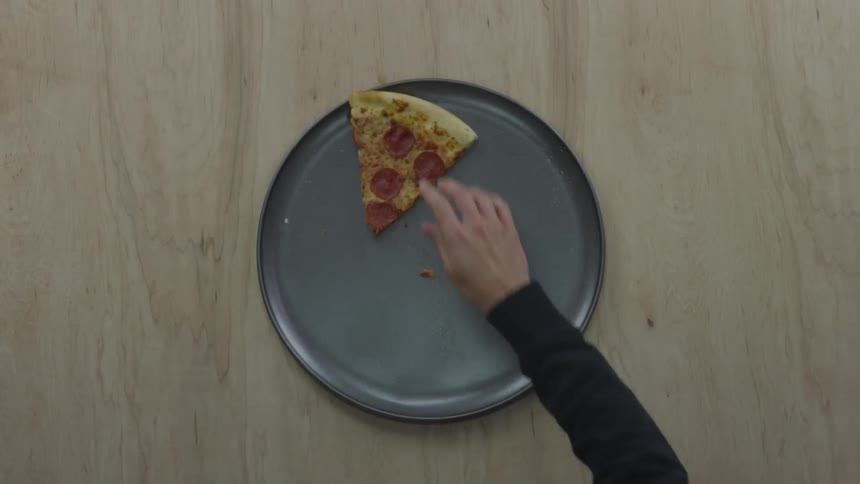 One person smacks the hand of another person reaching for the final piece of pepperoni pizza on a silver pan