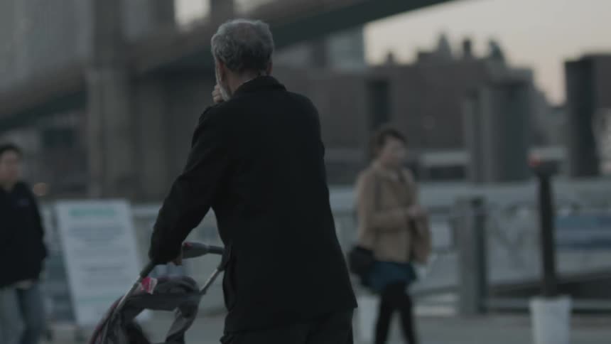 An old man pushing a stroller with a child in an urban area