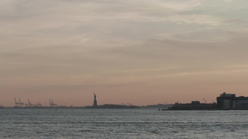 Water rippling with the statue of liberty in the distance