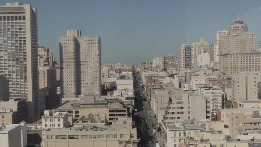 An elevated view of a long street in a city and its many buildings