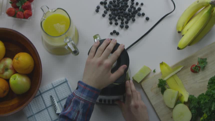 Person puts a lid on a blender and runs it on top of a kitchen counter