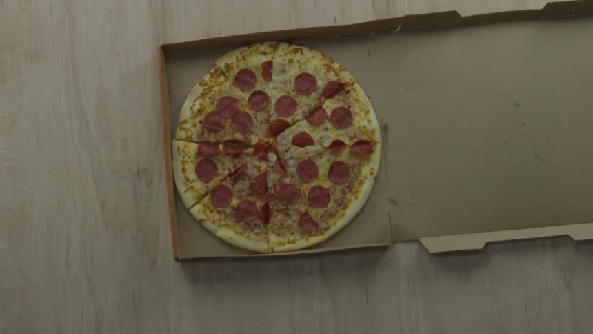 A sliced pizza being placed in a box