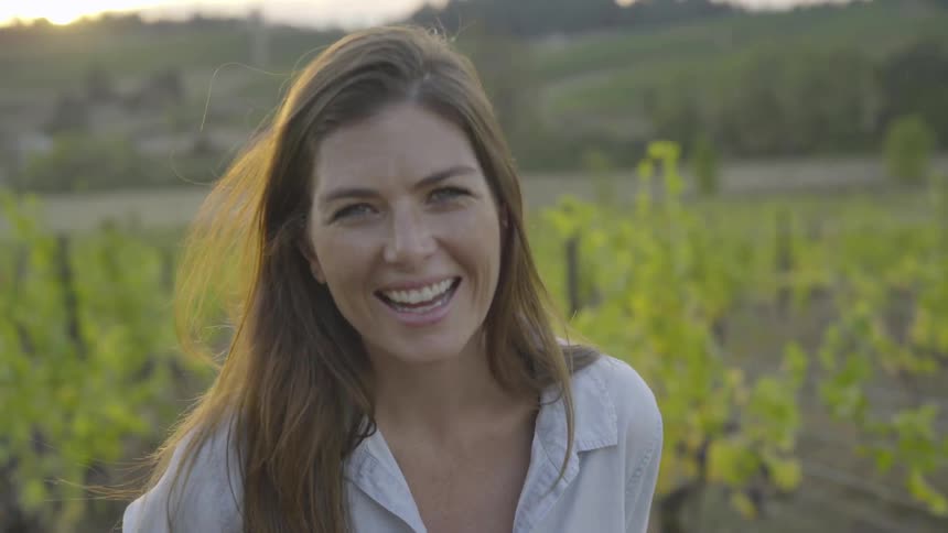 A woman laughing in a field
