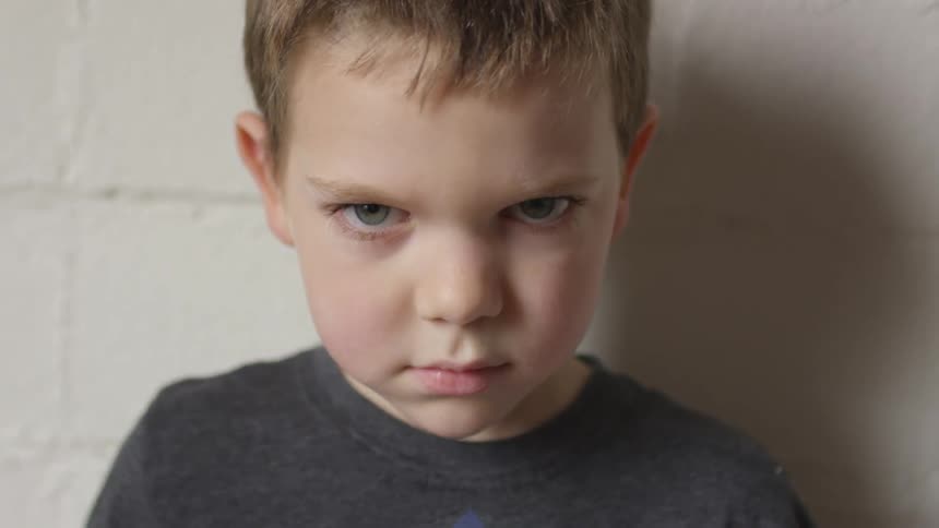A young boy stares angrily