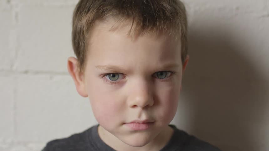 A boy scowling at the camera