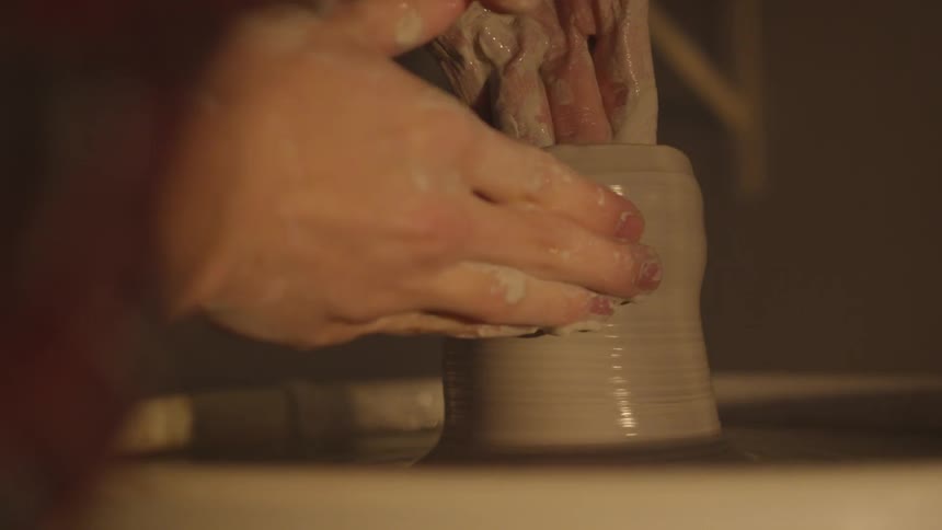 Person works on a potter's wheel