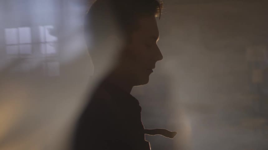 A man stands in a room surrounded by fog