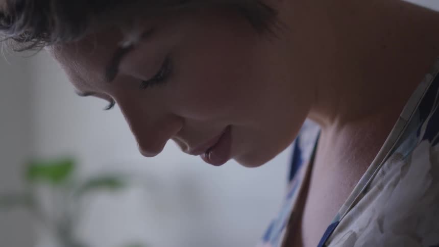 Woman looks down in room
