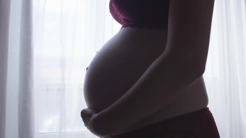 A pregnant woman holding her belly