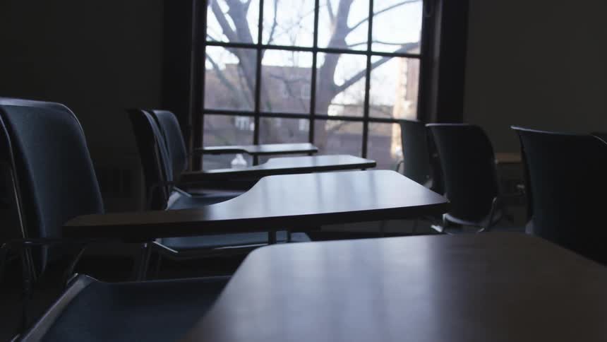 An empty school classroom with rows of desks