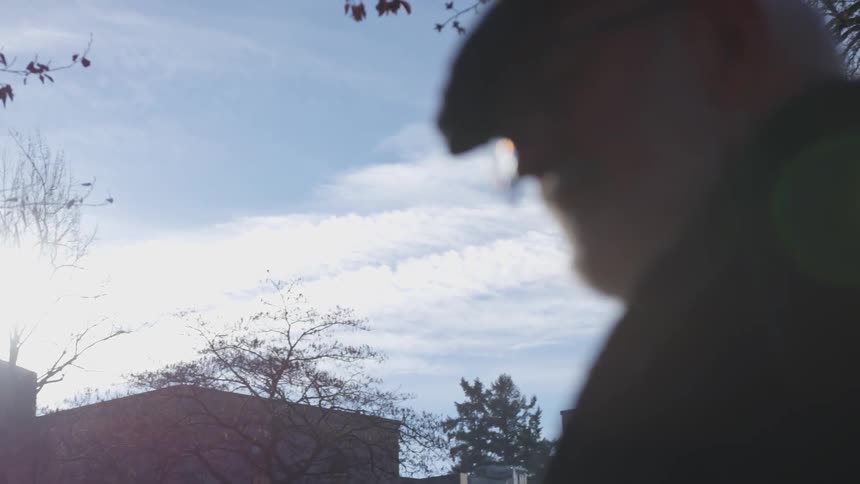 A elderly man sitting outdoors on a sunny day