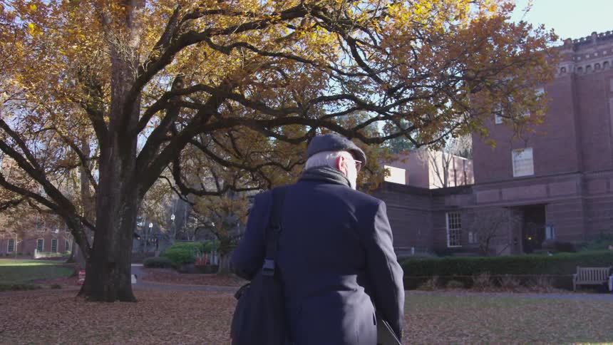 Elderly man walking with a bag on his shoulder