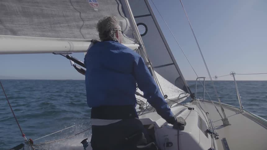A man is enjoying speeding along in his boat on the ocean on a fine day