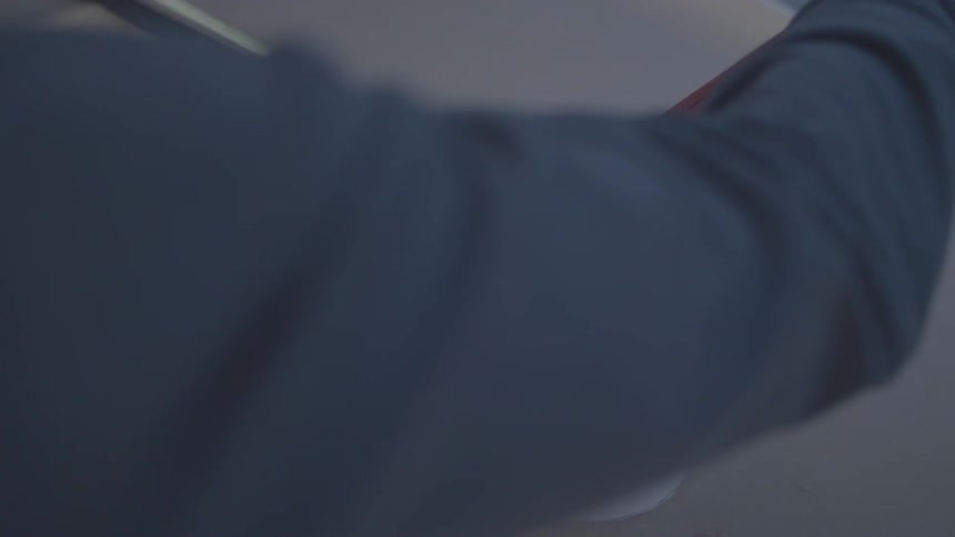 A person uses a gloved hand to turn a sail winch on a boat