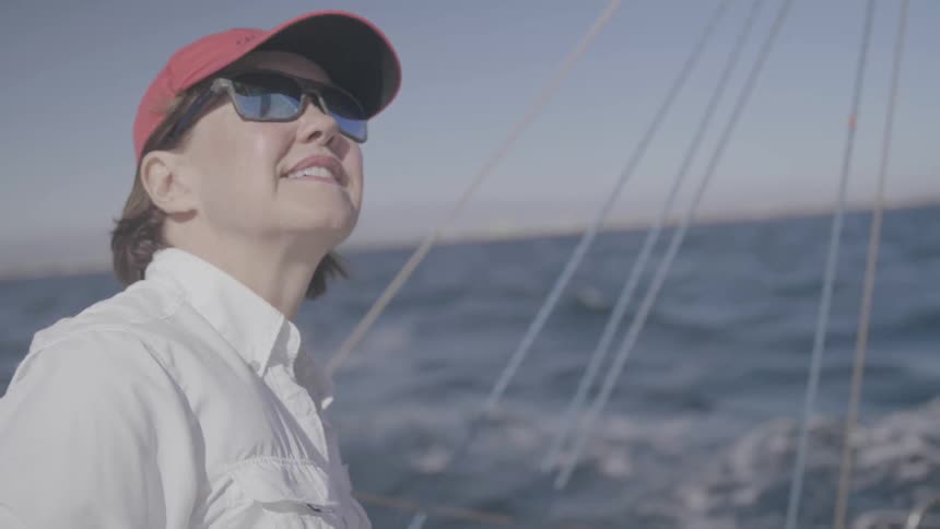Woman wearing a hat rides on boat